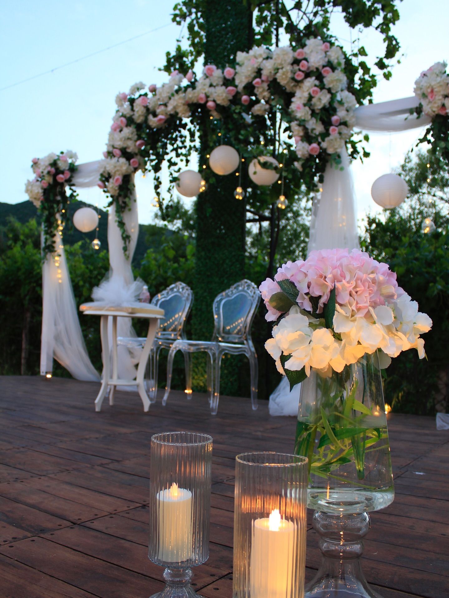 Candles and pink hydrangeas on the wooden stage