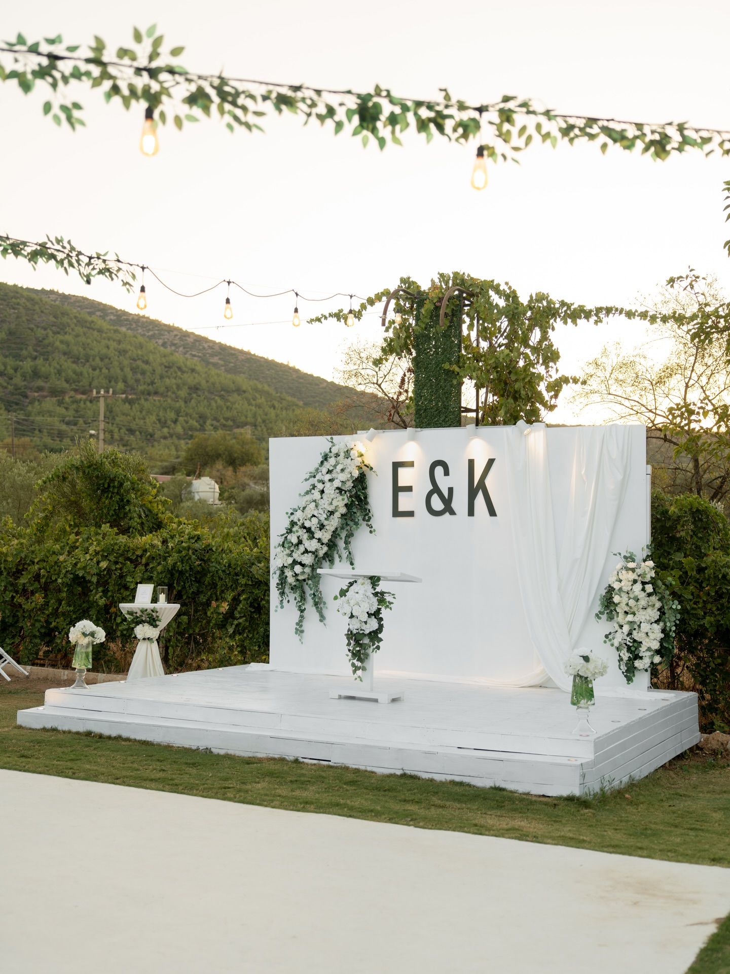 White stage and flower backdrop overlooking the hills