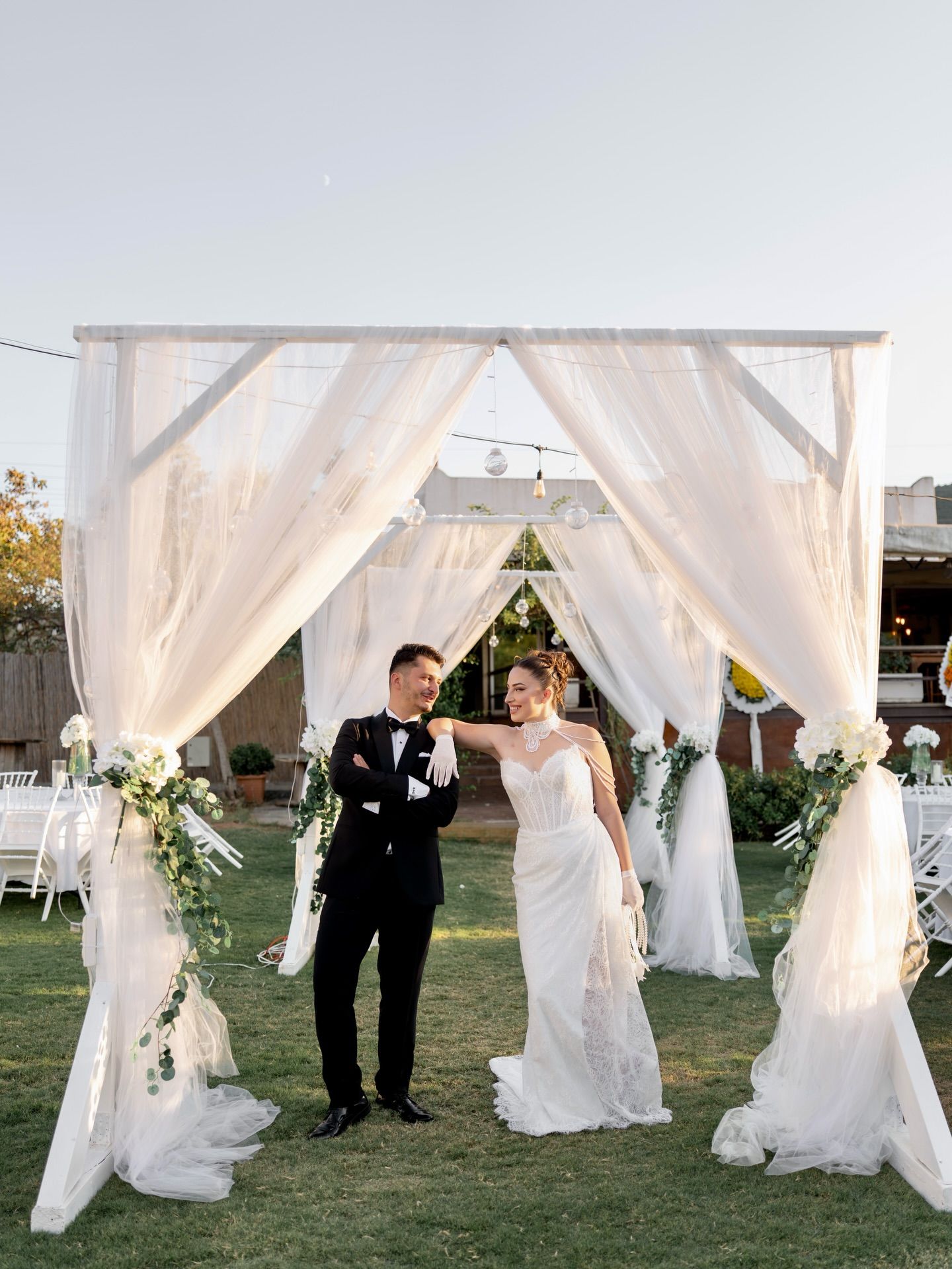 Bride and groom in front of a tulle canopy